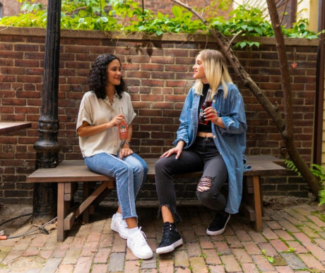 woman holding drinks talking